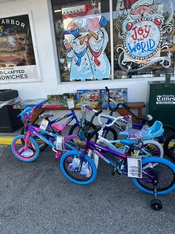 Children's bicycles lined up beneath the festively painted windows of the Safety Harbor deli.